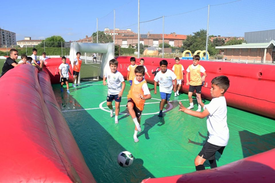 Niños jugando al fútbol dentro de un hinchable